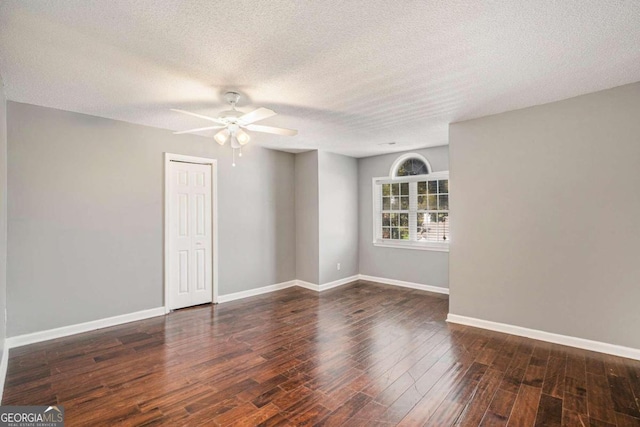 empty room with a textured ceiling, dark hardwood / wood-style floors, and ceiling fan