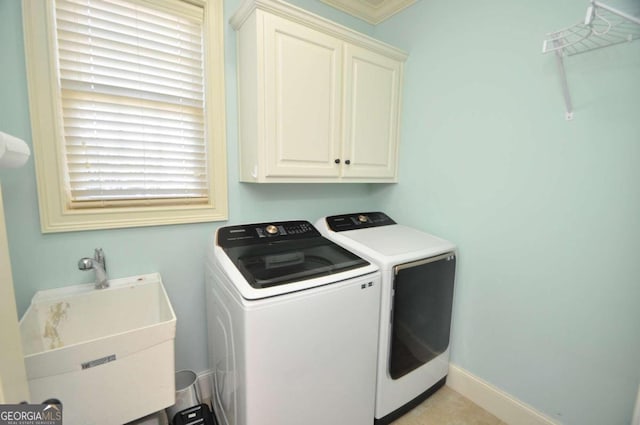 clothes washing area featuring independent washer and dryer, cabinets, and sink