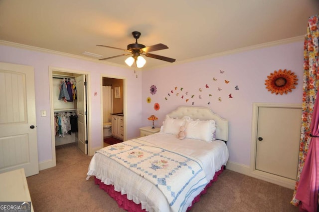 carpeted bedroom with a closet, ceiling fan, crown molding, and ensuite bath