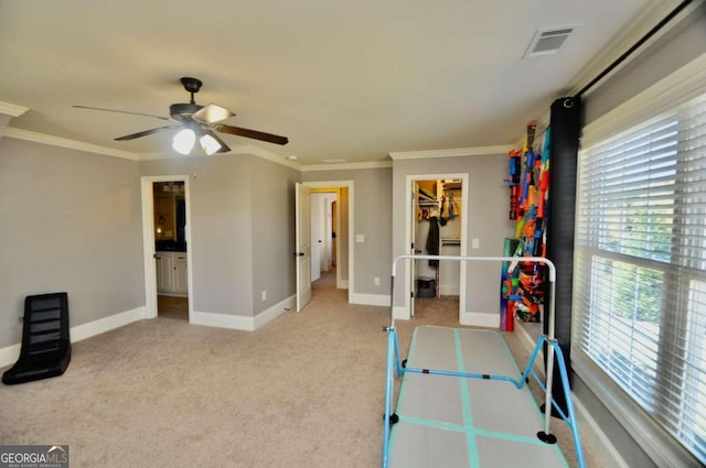 interior space with light carpet, ornamental molding, and ceiling fan