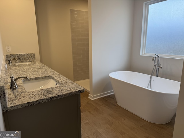 bathroom featuring wood-type flooring, vanity, and plus walk in shower