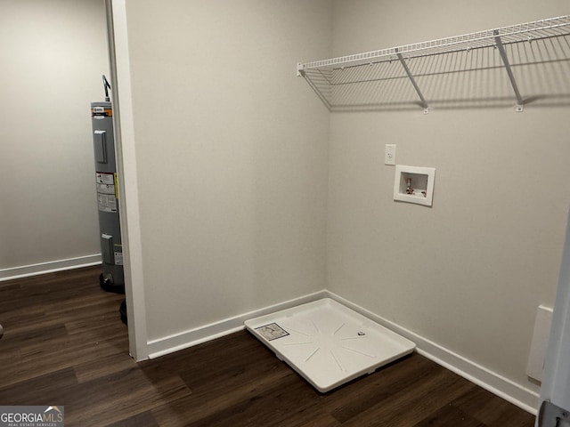 washroom featuring electric water heater, dark hardwood / wood-style flooring, and hookup for a washing machine