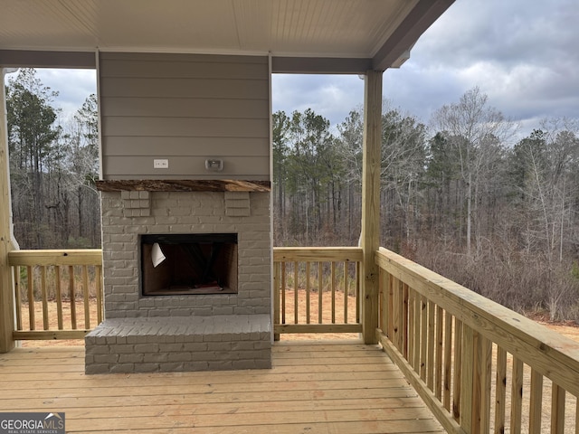 wooden deck featuring an outdoor brick fireplace