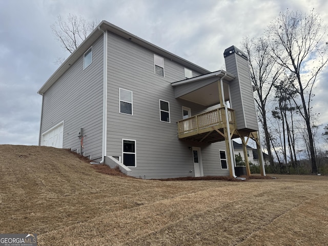 rear view of house with cooling unit, a yard, and a garage