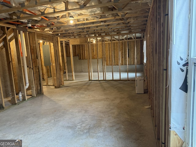 miscellaneous room with electric panel and concrete flooring