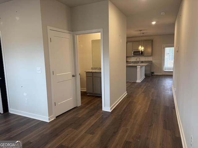 corridor with dark hardwood / wood-style floors and sink