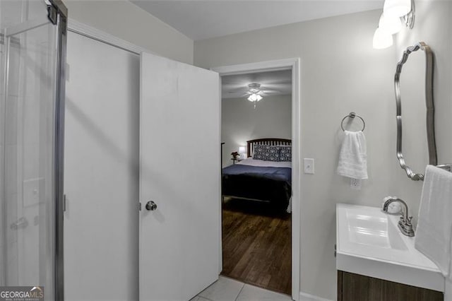 bathroom with tile patterned floors, ceiling fan, vanity, and a shower with shower door