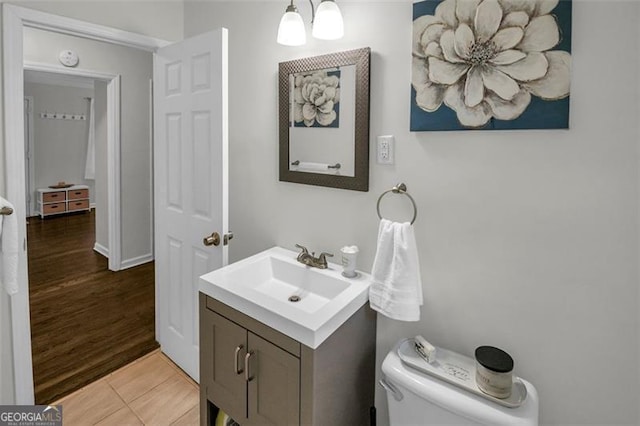 bathroom with toilet, vanity, a chandelier, and tile patterned floors