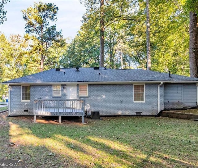 back of property featuring a deck, cooling unit, and a lawn