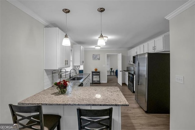 kitchen featuring crown molding, sink, kitchen peninsula, white cabinetry, and stainless steel appliances