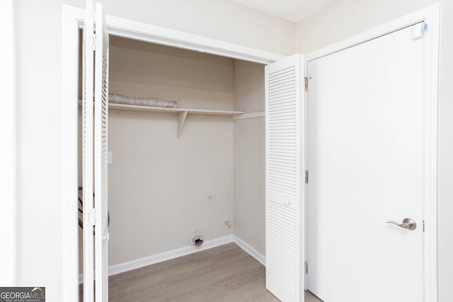 laundry room featuring electric dryer hookup and light wood-type flooring