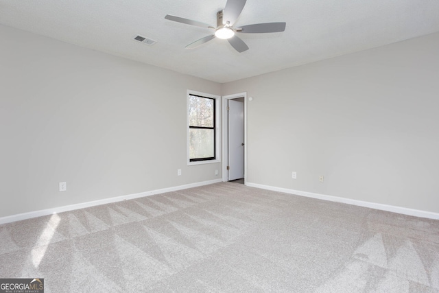 carpeted spare room featuring ceiling fan