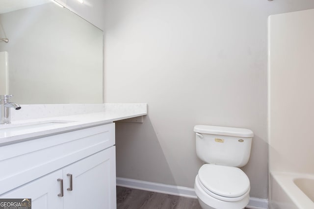 bathroom with vanity, toilet, wood-type flooring, and a tub