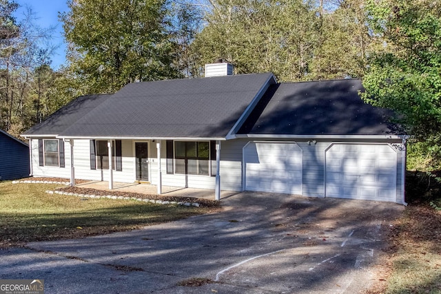 view of front facade with covered porch, a garage, and a front yard