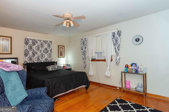 bedroom featuring hardwood / wood-style flooring, ceiling fan, and cooling unit