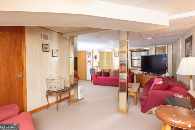 carpeted living room with wooden walls