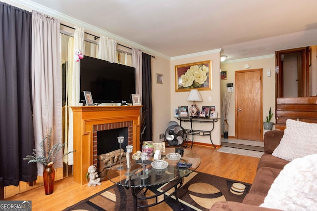 living room with crown molding, light wood-type flooring, and a fireplace