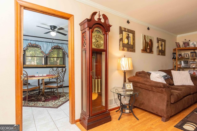 living room with ceiling fan and ornamental molding