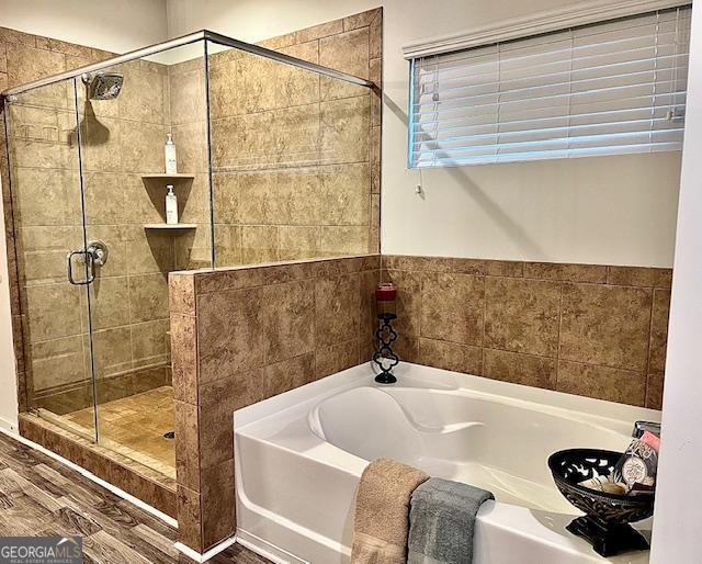 bathroom with hardwood / wood-style floors and separate shower and tub