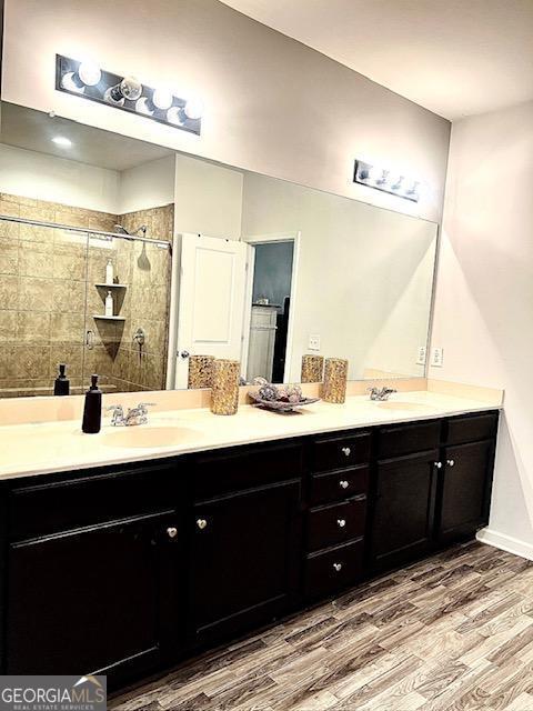 bathroom featuring vanity, an enclosed shower, and wood-type flooring