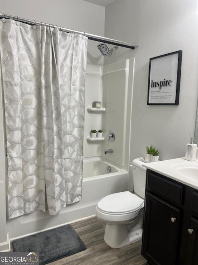 full bathroom featuring hardwood / wood-style floors, vanity, toilet, and shower / bath combo