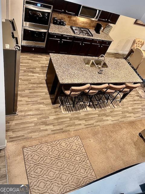 interior space featuring double oven, light stone countertops, and light hardwood / wood-style flooring