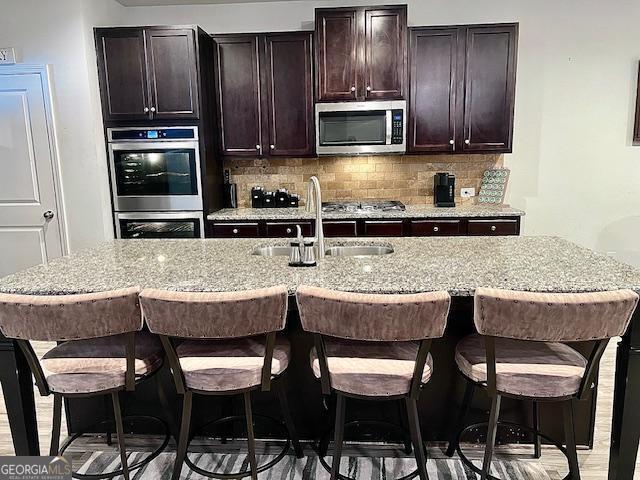 kitchen with a kitchen bar, sink, and appliances with stainless steel finishes