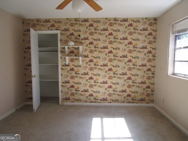 carpeted spare room with ceiling fan