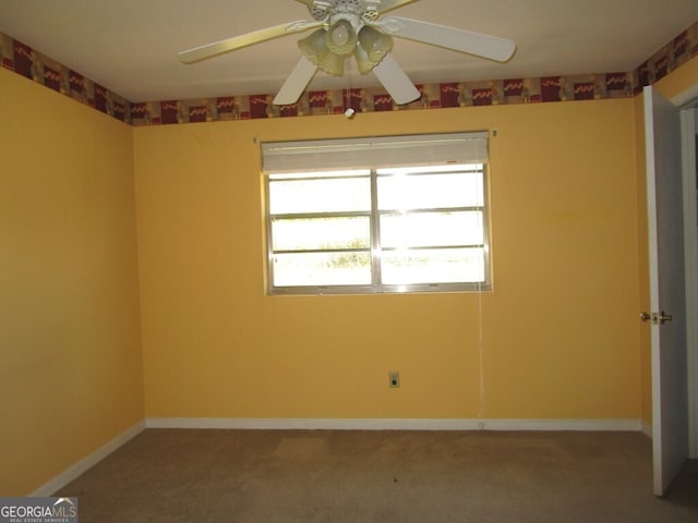 carpeted spare room featuring ceiling fan