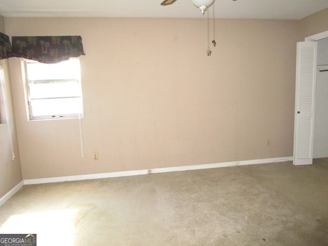 carpeted empty room featuring ceiling fan