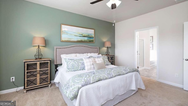 carpeted bedroom with ensuite bath and ceiling fan