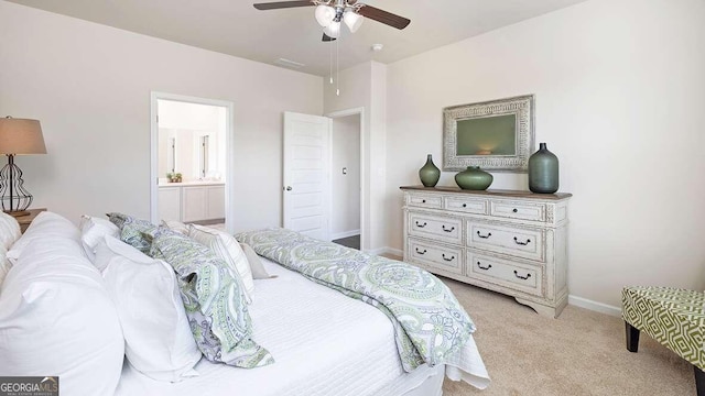 bedroom with ensuite bathroom, ceiling fan, and light colored carpet