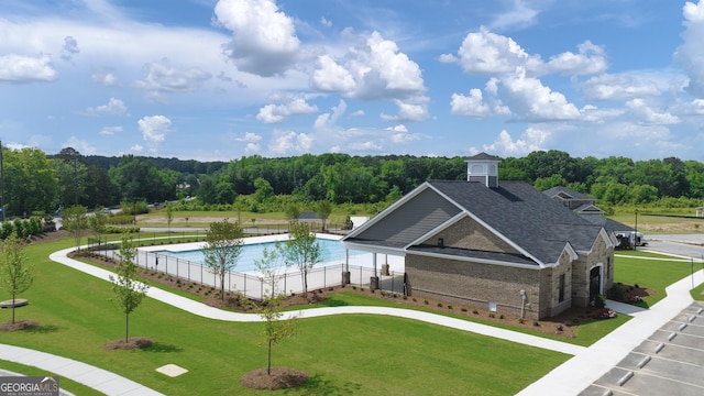 view of swimming pool with a lawn