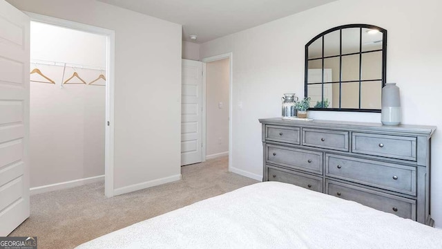 carpeted bedroom with a walk in closet