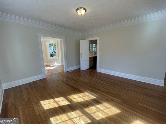 unfurnished room with ornamental molding, a textured ceiling, and dark hardwood / wood-style flooring