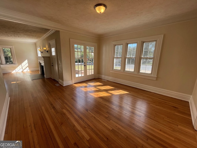 empty room featuring hardwood / wood-style floors, crown molding, and a healthy amount of sunlight