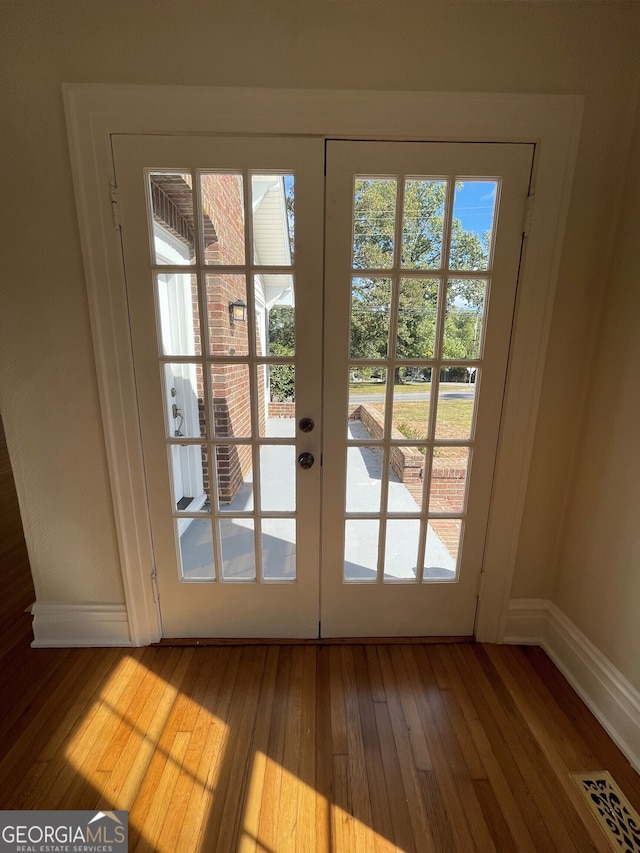 entryway featuring french doors, hardwood / wood-style flooring, and a healthy amount of sunlight