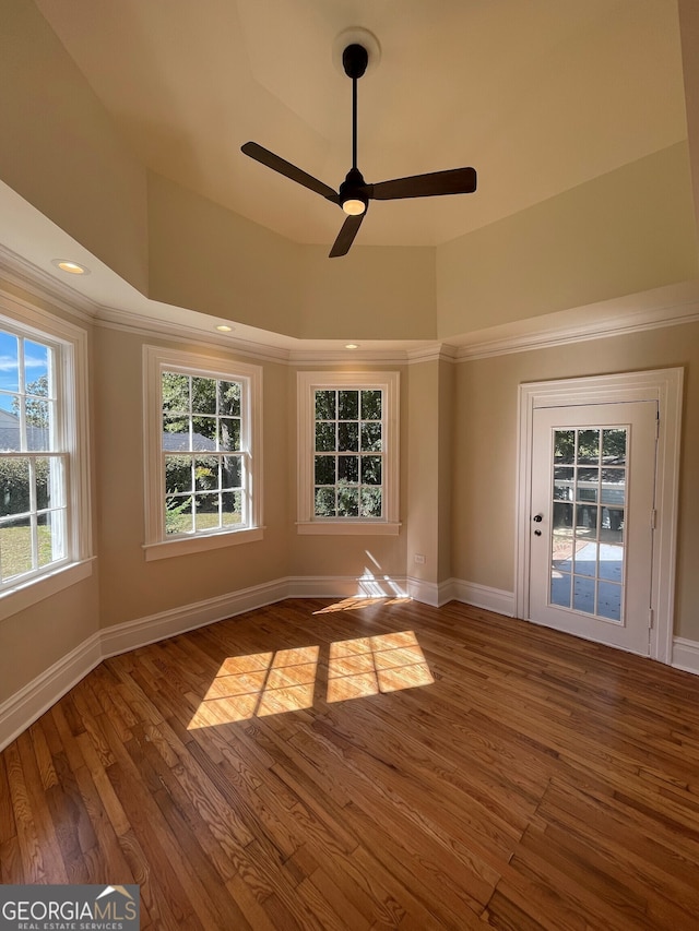unfurnished room featuring hardwood / wood-style flooring, a healthy amount of sunlight, and ceiling fan