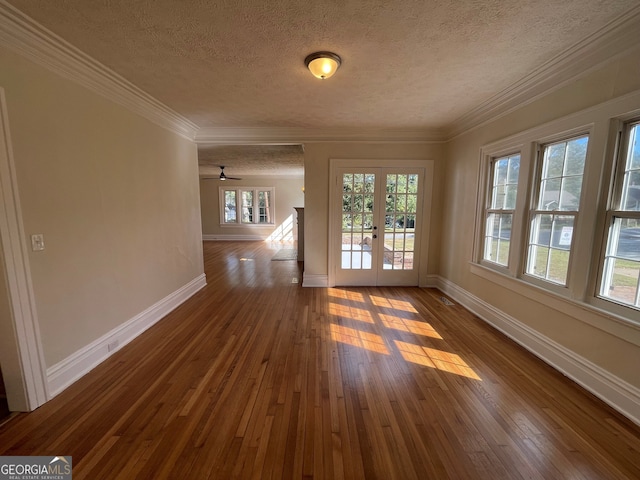 empty room featuring ornamental molding, hardwood / wood-style floors, a textured ceiling, and ceiling fan