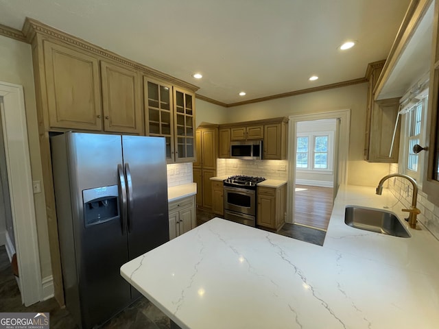 kitchen with appliances with stainless steel finishes, decorative backsplash, ornamental molding, and sink