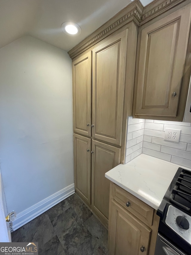 kitchen with light stone countertops, decorative backsplash, and stove