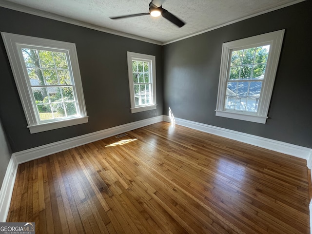 unfurnished room with hardwood / wood-style flooring, a healthy amount of sunlight, and crown molding