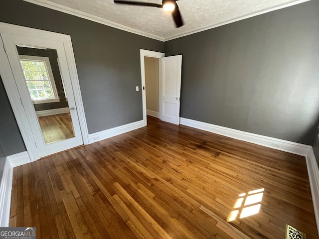 unfurnished room featuring ornamental molding, a textured ceiling, wood-type flooring, and ceiling fan