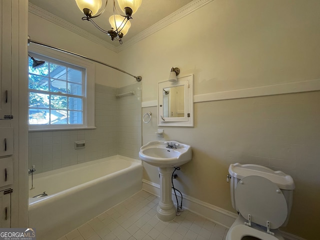 bathroom featuring tile patterned floors, toilet, ornamental molding, tiled shower / bath combo, and a chandelier