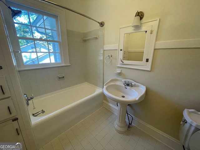 bathroom with tiled shower / bath combo, tile patterned flooring, toilet, and plenty of natural light