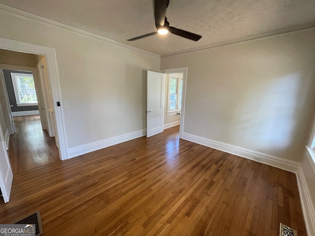 unfurnished room with crown molding, dark hardwood / wood-style floors, a textured ceiling, and ceiling fan