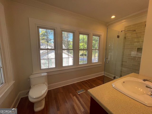 bathroom featuring toilet, wood-type flooring, a healthy amount of sunlight, and an enclosed shower