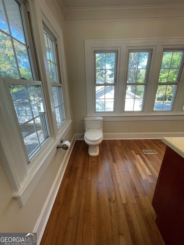 bathroom with vanity, toilet, hardwood / wood-style flooring, and crown molding