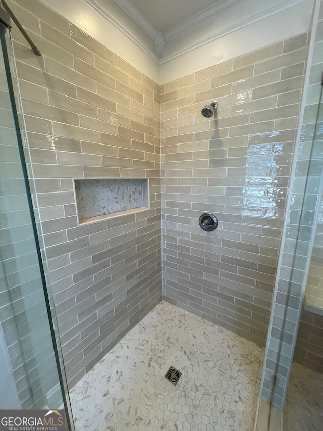 bathroom featuring ornamental molding and walk in shower