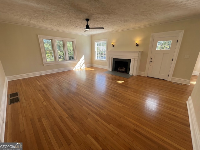unfurnished living room with ceiling fan, a textured ceiling, and light wood-type flooring